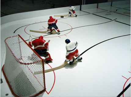 A picture of a table top hockey game focusing on a goalie at work